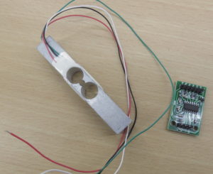 A load cell (left hand side) and an HX711 breakout board (right hand side).